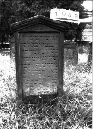 Grabstein 1049 (Index: 100098948) Maße HxBxT: 125x56x10 cm Besonderheit: kulturhistorisch wertvoll / hist.-wiss. Gründe (Gemeindestellung): Grabstein 1049