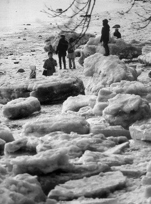 Hamburg-Blankenese. Winter 1970. Eisschollen türmen sich am zugefrorenen Elbufer. Dieses Schauspiel lassen sich Spaziergänger nicht entgehen