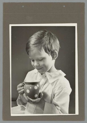 Portrait eines Jungen in Hemd mit Tasse