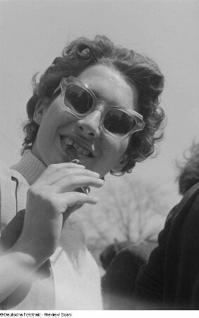 Portrait einer Zuschauerin mit Sonnenbrille und Stift in der Hand beim 6. Leipziger Stadtparkrennen