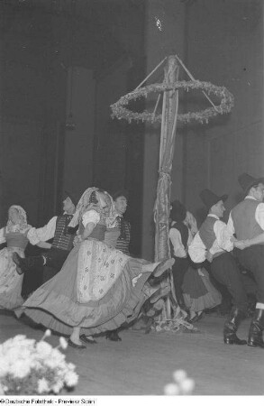 Menschen in Tracht tanzen bei einer Veranstaltung zum Gedenken an die Völkerschlacht um einen Maibaum