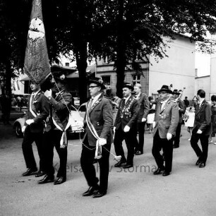 Schützenfest: Veranstalter Ahrensburger Schützengilde: Große Straße: Umzug: Fahnenabordnung der Schützengilde marschiert, dahinter Schützenkönig Günther Paulsen in Begleitung von Heiner Grahl, Josef Gerads: hinten parkende Autos, Zuschauer, Bäume