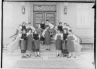 Haushaltungsschule in Gammertingen 1931; Junge Frauen mit Schürzen bei einer Aufführung mit Geigenspielerin auf einer Treppe vor dem Hauseingang