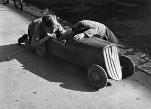 Kinderbilder. Zwei kleine Jungen mit einem Spielzeugauto in Bayreuth