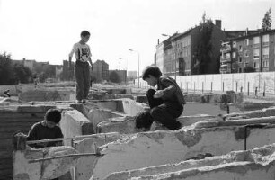 Kinder spielen auf den Resten der Mauer im Grenzstreifen