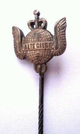 Mitgliedsabzeichen des Vereins "Alte Gilde" (mit langer Nadel) : Sammlung Beinhorn. Mitgliedsabzeichen des Vereins "Alte Gilde" (geflügelte Weltkugel mit Merkurstab und Aufschrift "Alte Gilde", mit langer Nadel; rückseitig: M. & W. ST.). Metall; Maße (ohne Nadel) 16 x 14 mm (nach 1900; Mayer & Wilhelm, Stuttgart). Dresden: SLUB R c 0301
