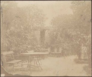 Partie im Schloßgarten mit Sitzmöbel.