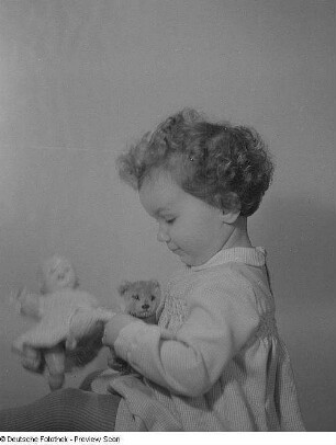 Porträt eines kleinen Mädchens mit Puppe und Teddybär
