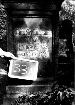 Grabstein 33 (Index: 100110033) Material: Sandstein Zustand: leicht verwittert Maße HxBxT: 140x57x25 cm Beschreibung: Stele, getreppter Sockel, Giebel mit stilisierten Eckakroteren, Schriftfeld rechteckig eingetieft: Grabstein 33A