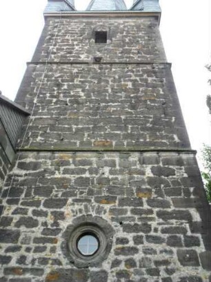 Evangelische Kirche - Kirchturm von Norden mit Werksteinen im Mauersteinverband sowie Kleeblattfenster (Schießscharte) im Obergeschoß