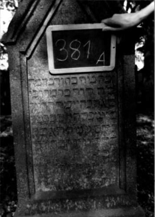 Grabstein 381 (Index: 100111859) Material: Sandstein Zustand: leicht verwittert Maße HxBxT: 153x55x20 cm Beschreibung: Stele, getreppter Sockel, eingezogener giebelartiger Abschluß, rechteckig erhöht, Schriftfeld eingetieft Symbolik: segnende Hände: Grabstein 381A