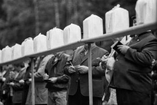 Finkenmanöver in Benneckenstein, Ostharz, 20.05.1991. Die Finken sitzen einzeln in verkleidetetn Käfigen und singen um die Wette. Wer am Längsten schlägt, wird von einer Jury zum Sieger erklärt. - Anschließend gibt es am Waldrand noch eine kleines Volksfest mit Marschmusik und Lagerfeuer