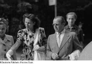 Bruni Löbel, Hertha Feiler und Heinz Rühmann, umgeben von anderen Personen