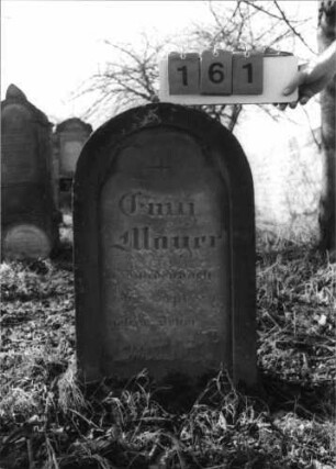 Grabstein 161 (Index: 100116287) Material: Sandstein Zustand: teilweise verwittert Maße HxBxT: 80x44x25 cm Beschreibung: Stele mit Rundbogenabschluß, eingetieftes Schriftfeld Besonderheit: Kindergrab: Grabstein 161