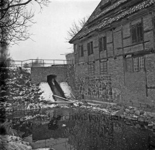 Drahtmühle: Restaurierung: vorn Mühlenbach: links Brücke mit Wehr: oben rechts Stapel mit Brettern: links Baum: Winter