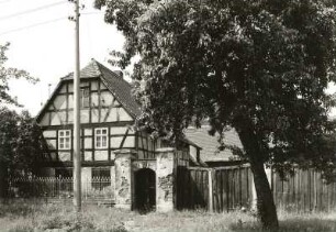 Großpösna-Dreiskau-Muckern, Dorfstraße 5. Dreiseithof (um 1800). Straßenansicht des Wohnstallhauses mit Einfriedung und Torbogen