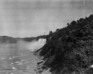 An den Niagara Fällen : Blick vom Terrapin Point über das Flussufer von Goat Island hin zu den American Falls. Im Hintergrund die bis in das Jahr 1938 bestehende Upper Steel Arch Bridge.