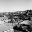 Vogelperspektive: von Hochhaus der Kreisverwaltung: Blick nach Osten: vorne Kreistagssitzungssaal: links Häuser an Reimer-Hansen-Straße: Bildmitte Mommsenstraße, Bahnhofsvorplatz mit Parkplatz, parkende Autos: dahinter Bahnhofsgelände, Bahnsteig, Personenzug, Bahnhofsinsel mit Güterbahnhof: dahinter Betriebe an Ladestraße: hinten rechts Häuser an Ratzeburger Straße: im Hintergrund Hochhäuser am Schanzenbarg, am Masurenweg, Up den Pahl