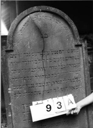 Grabstein 93 (Index: 100094798) Material: Sandstein Zustand: längs gesprungen Maße HxBxT: 186x70x13 cm Beschreibung: Stele, eingezogener Rundbogenabschluß, Schriftfeld eingetieft Besonderheit: gereimter 6-Zeiler; - Zit.Ps.45, 14: Grabstein 93A