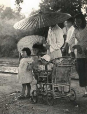 Peking, China, Alltagsszene : Familie mit Schirmen und Kinderwagen