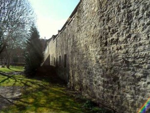 Stadtbefestigung - Ansicht im Osten mit Stadtmauer (Werksteine im Mauersteinverband) flankierend nach Süden sowie ehemaligem Stadtgraben (aufgefüllt)