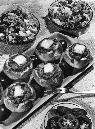Krafts Rezeptaufnahmen. Gefüllte und überbackenen Brötchen. Daneben zwei Salatschüsseln