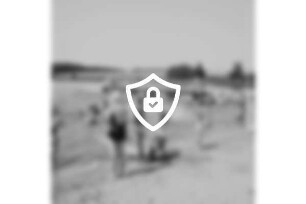 Freibad Poggensee: Badegäste am Sandstrand und im Wasser, im Hintergrund der Badesteg