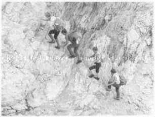 Vier Wanderer beim Bezwingen des Berges (Altersgruppe 14-17)