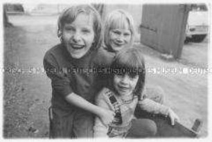 Drei lachende Kinder (Altersgruppe 18-21)