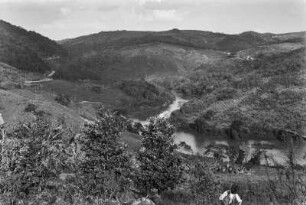Flusslandschaft mit Hügeln : Ein Fluss fließt in einem Tal zwischen Hügeln hindurch. Rechts auf dem Hang eine Plantage, im Vordergrund ein Mann. Baumgruppen links und im Mittelgrund.
