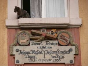 Hauszeichen und kleine Katze im Zentrum