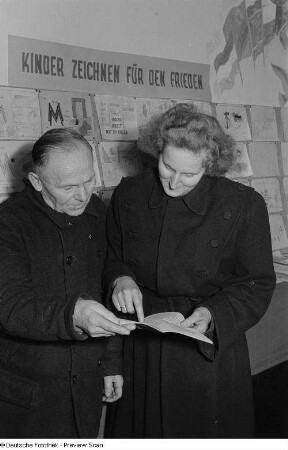 Ausstellungsbesucher während des Lesens eines Prospektes