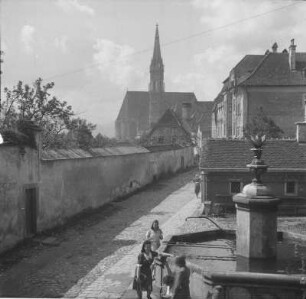 Frauen am Brunnen : Drei Frauen an einem Brunnen. Im Hintergrund der Kirchturm der Stadtpfarrkirche Steyr.