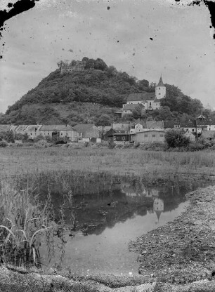Ortsteilansicht mit Kirche und Burgruine, wahrscheinlich in Böhmen