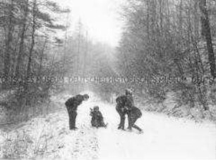 Familienspaß auf Waldweg bei Schneefall