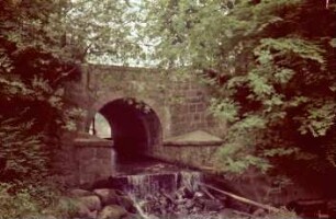 Mühlenredder: Brücke über Abfluss des Schlossgrabens in Aue: Seitenansicht von Norden: oben Geländer: vorne rechts Grundablassrohr