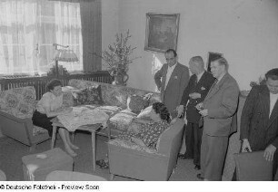Besucher der Herbstmesse 1953 betrachten eine Wohnzimmereinrichtung