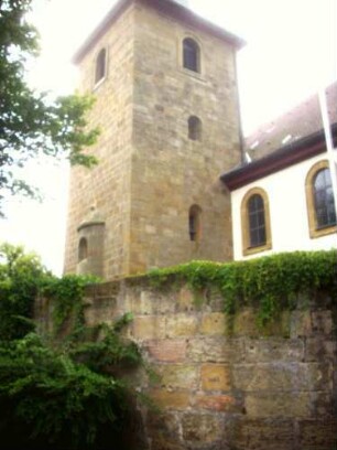 Ansicht von Nordosten mit Kirchturm (im Kern Romanisch - Glockengeschoß Barock erneuert) über Kirchhofmauer (Wehrgang im 18 Jh abgetragen)-Werksteine mit erhaltenen Zangenlöchern der Hebezeuge
