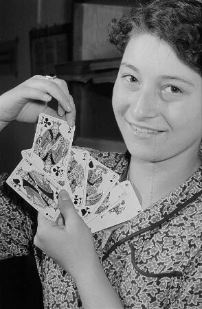 Eine Frau präsentiert Spielkarten aus der Altenburger Spielkartenfabrik