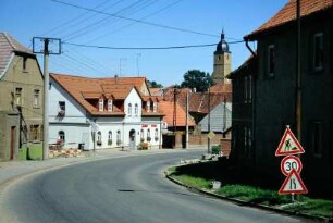 Straßenbogen am Ortseingang von Daasdorf her; links sanierte Apotheke