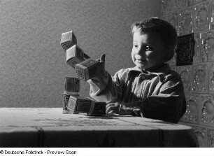 Kleiner Junge, mit Schachteln spielend