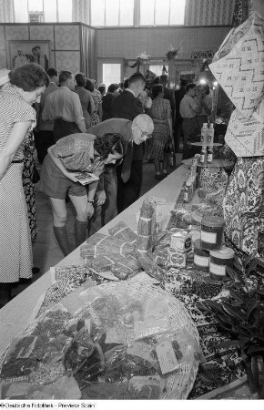 Besucher mustern Ausstellungsstücke der indischen Sektion auf der Leipziger Herbstmesse 1954