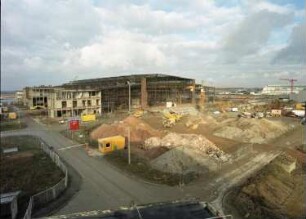 Dresden-Klotzsche, Flughafenstraße. Flughafen Dresden. Technikhalle (1998/2000). Ausheben der Baugrube. Ansicht der Südwestseite. Blick vom Dach des IMA Dresden
