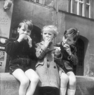 Berlin. Zwei Jungen und ein Mädchen beim Äpfelessen