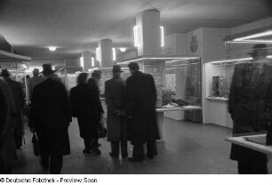 Besucher vor Vitrinen mit Koffern und Taschen