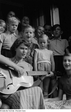 Kinder beim Singen mit Betreuerin im Hauseingang der Alten Winkelmühle