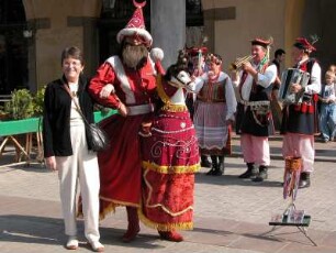 die traditionelle Figur des "Lajkonik", ein Tatare mit Pferd, dahinter Straßenmusiker, am Hauptmarkt, mit Tourist