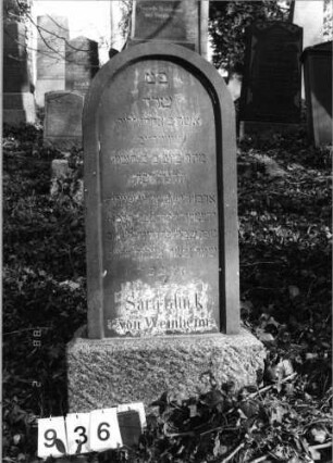 Grabstein 936 (Index: 99802610) Material: Sandstein Zustand: leicht verwittert Maße HxBxT: 122x49x18 cm Beschreibung: Sockel, Stele mit Rundbogen und profilierter Rand Besonderheit: Endreim: Grabstein 936