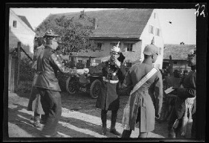 Kriegsminister von Kress, Hauptmann Sperr und Major Schuster, alle mit Pickelhaube und ein Chauffeur (?) mit Lederjacke und Schirmmütze auf einer Ortsstraße