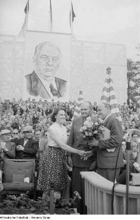 Paul Scholz während der Übergabe eines Blumenstraußes